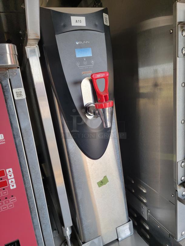 Bunn hot water dispenser, model with red lever, stainless steel body, energy saver mode feature, minor wear visible.