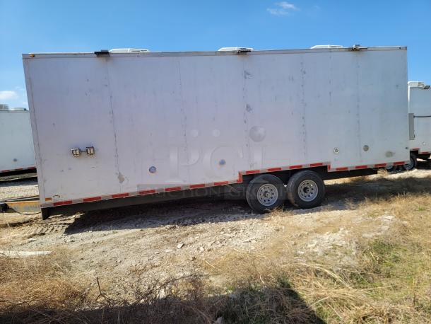 White double-axle cargo trailer, exterior wear visible. Equipped with rooftop units and side lights. Suitable for transport.