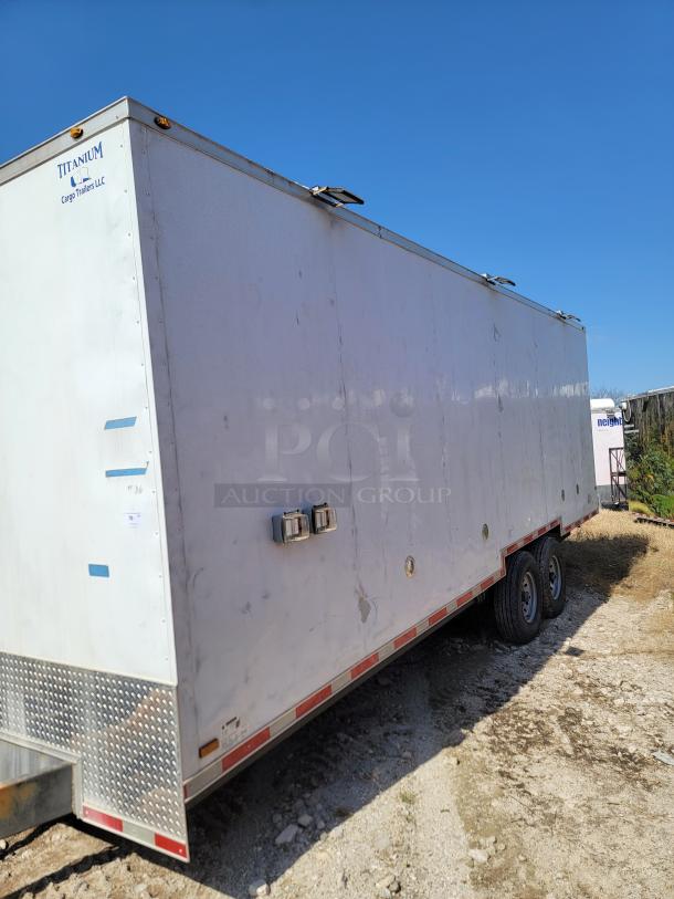 Titanium Cargo Trailers LLC enclosed trailer, dual axle, visible wear, metal construction, side markers, exterior locks.