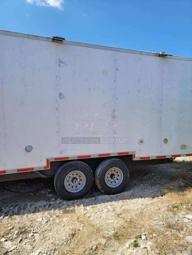White utility trailer with dual axles, red reflective tape, and visible latches. Some wear marks are evident.