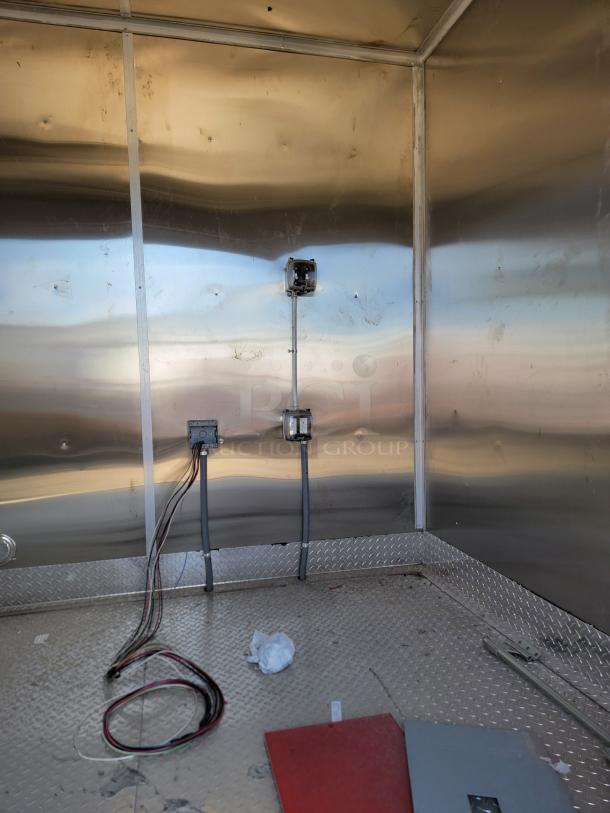 Industrial metal enclosure with wiring, conduit boxes, and diamond plate flooring. Minor scuffs visible.