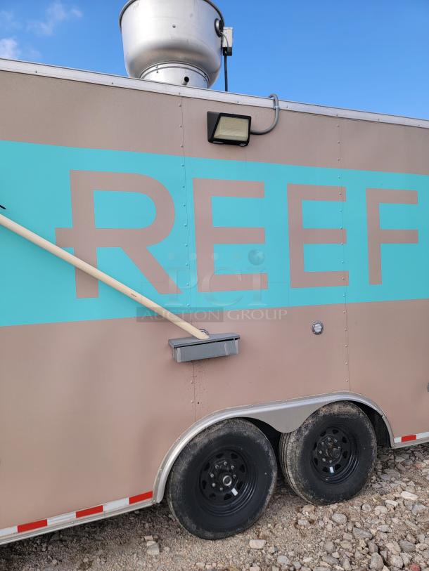 Mobile food trailer with "REEF" branding, beige and teal finish, dual axle wheels, external light, rooftop vent, used condition.