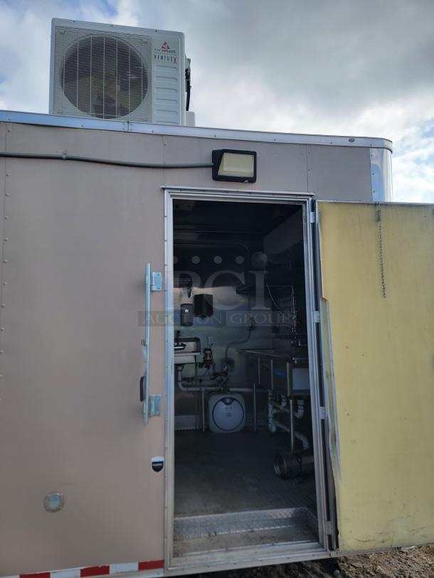 Mobile unit with open door, revealing interior plumbing and equipment. Exterior features a Haier Medage Ventus X air unit.