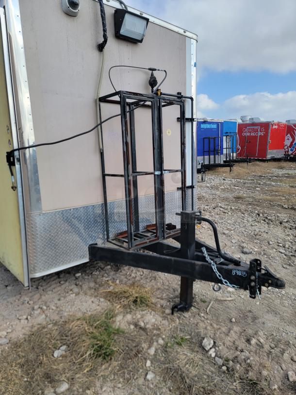 Mobile food trailer with dual propane tank holder, black hitch, and chain. Good condition, suitable for food service.