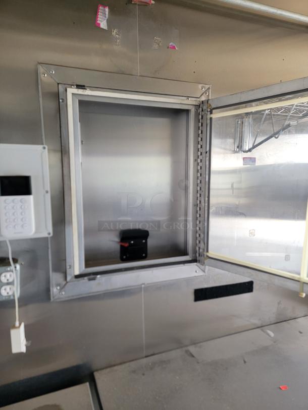 Stainless steel pass-through window with security keypad; signs of use; no visible brand or model markings.