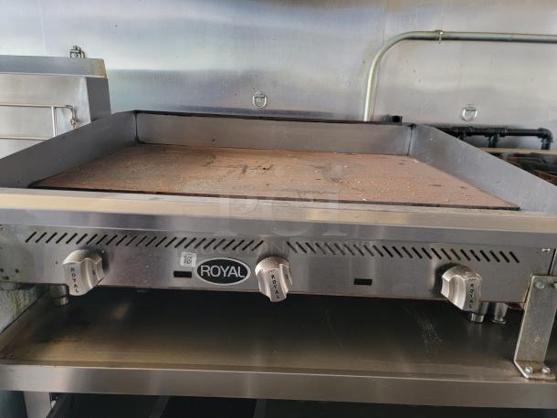 Royal commercial griddle with three controls, stainless steel body, and visible minor wear. Model tag indicates usage details.