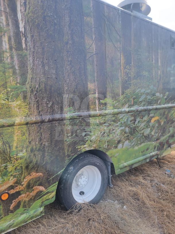 2013 Freightliner MT45 22’ mobile kitchen with forest-themed wrap. Featuring a Utilimaster body and visible rear tire.