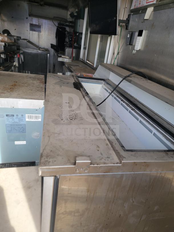 Interior view of the 2013 Freightliner MT45 mobile kitchen, showcasing Arctic Air refrigeration. Visible dust and wear.