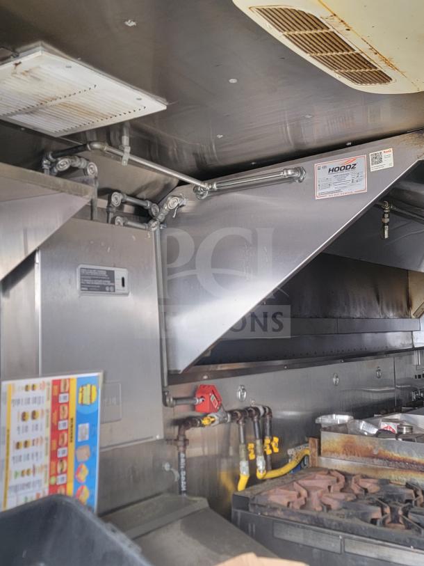 2013 Freightliner MT45 mobile kitchen interior featuring professional Hoodz ventilation system and stainless-steel fixtures.