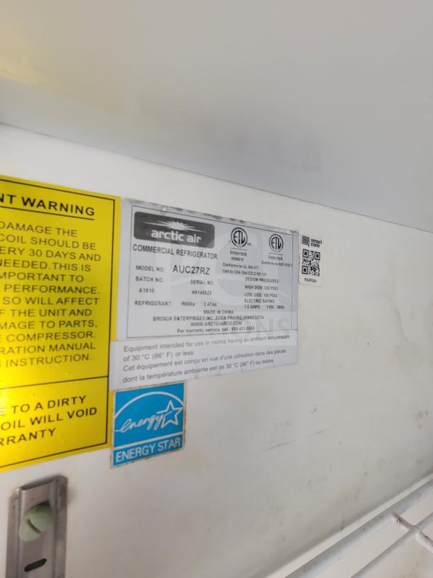 Arctic Air commercial refrigerator label, model AUC27RZ, with Energy Star sticker and warnings visible.
