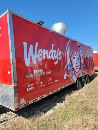Red Wendy's delivery trailer with logos for Uber Eats, DoorDash, Postmates, Grubhub. Used for delivery services.