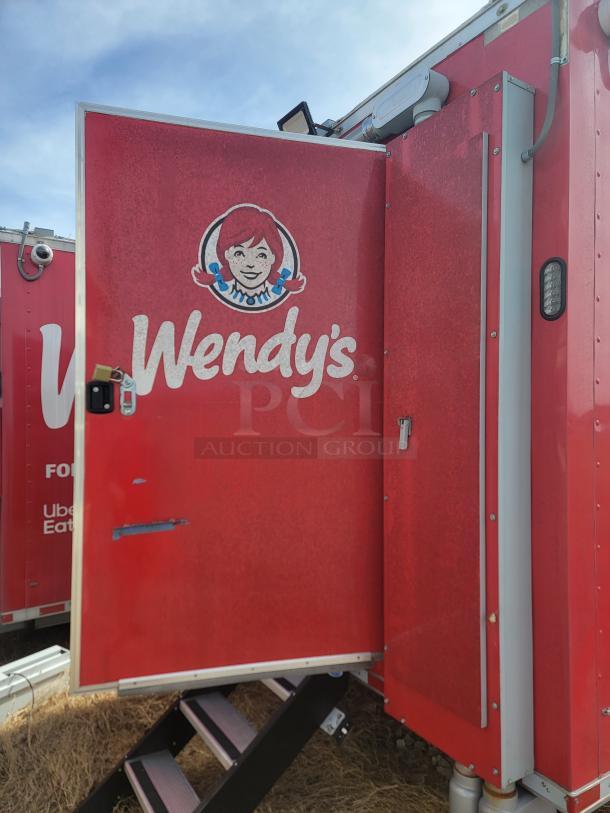 Red Wendy's mobile food truck with open door, logo visible. Exterior shows good condition; equipped with steps.