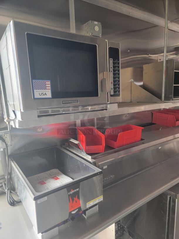 Menumaster microwave oven with keypad controls, USA-made label, mounted above a stainless steel Cayenne warm-holding unit.