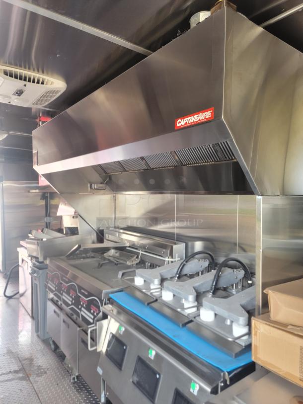 Commercial kitchen equipment with CaptiveAire exhaust hood, stainless steel finish, includes grills and cooking stations. Excellent condition.