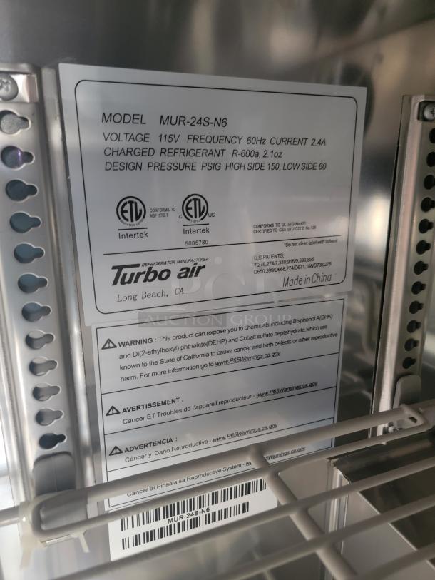 Turbo Air model MUR-24S-N6 refrigeration unit label showing voltage 115V, refrigerant R-600a, and safety warnings.