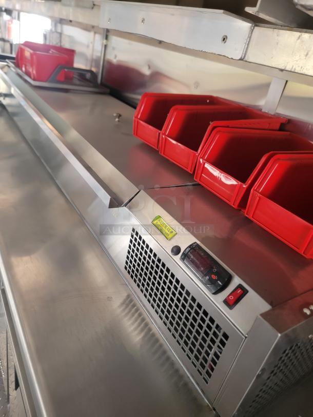 Stainless steel commercial prep station with red bins, built-in refrigeration, and digital temperature control. Good condition.