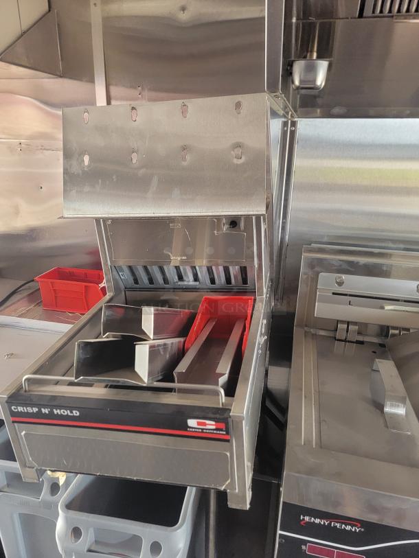 Commercial stainless steel food warmer by Crisp N' Hold, used condition. Features organizer trays and wall mount capability.