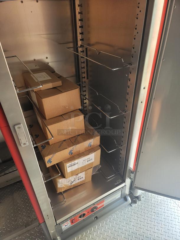 Metal storage cabinet with adjustable shelves, housing cardboard boxes. Labels display model numbers. Good condition.
