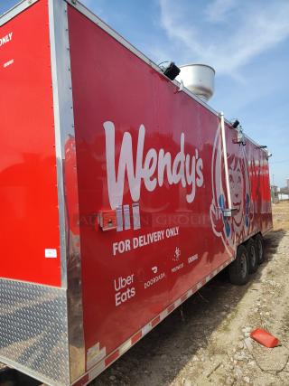 Red Wendy's mobile kitchen trailer with delivery logos, triple axles, and a rooftop vent. "For Delivery Only" signage visible.