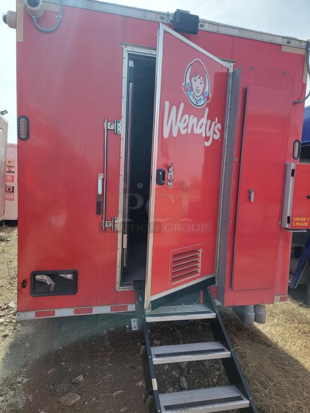 Red Wendy's food trailer with open door, folding steps, and visible logo. Exterior in good condition, vented panel on side.