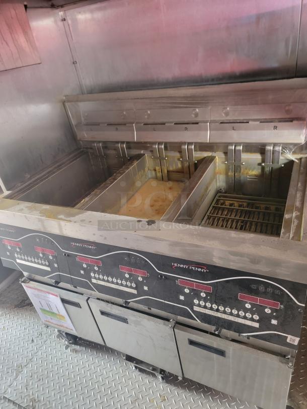 Henny Penny deep fryer with multiple compartments and control panels, stainless steel, used condition, visible controls and menu.