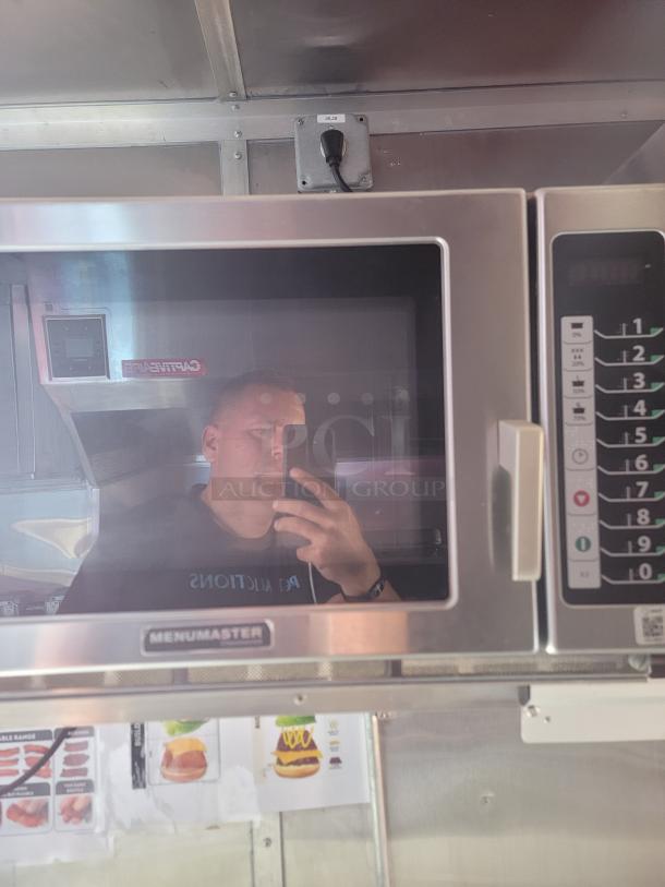 Menumaster commercial microwave oven, stainless steel, keypad controls, reflective door showing interior.