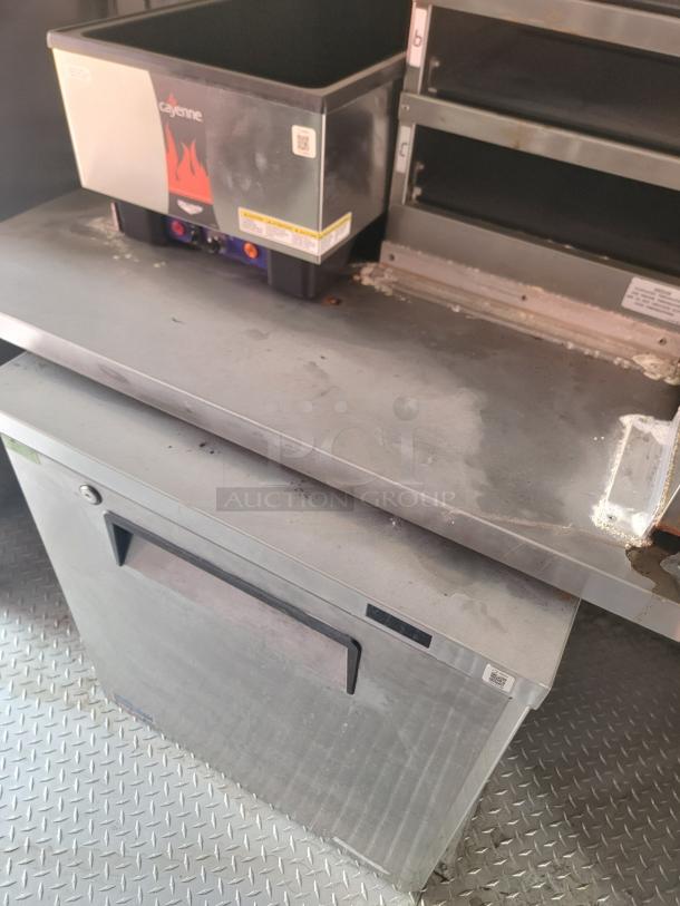 Stainless steel Cayenne food warmer in used condition, featuring a black top and flame logo. Visible controls and QR code on front.