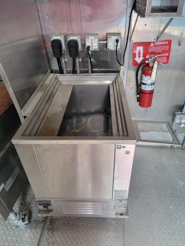 Stainless steel commercial refrigeration unit, used, features a top opening. Label indicates NSF certification. Minimal wear visible.