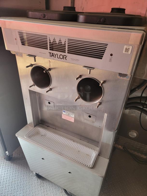 Taylor ice cream machine, dual spout, stainless steel, model not visible. Fair condition with visible wear.