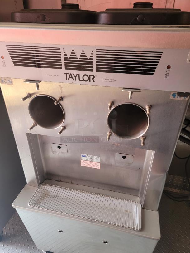 Taylor ice cream machine, silver, dual dispenser, commercial-grade. Visible label: Lane & McClain, Dallas, Texas. Used condition.