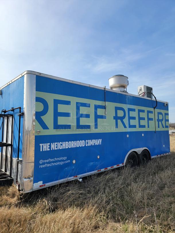 Blue mobile kitchen trailer with "Reef Technology" branding. Visible wear on sides. Equipped with ventilation and AC units.