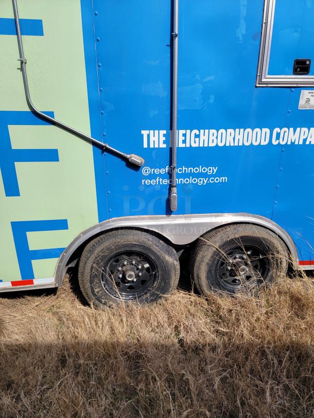 Blue mobile unit trailer with dual black wheels, part of Reef Technology. Includes company branding and contact details.