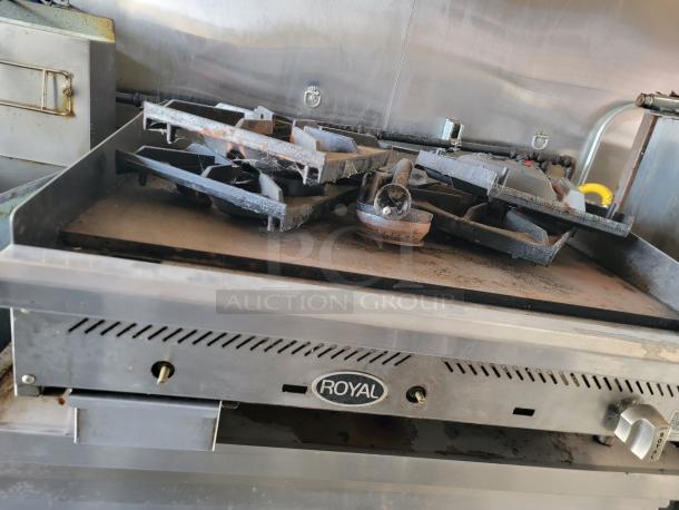Royal commercial gas range with six burners, showing signs of rust and wear. Suitable for professional kitchen use.