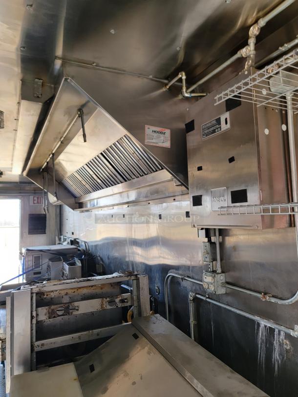 Commercial kitchen exhaust hood system, stainless steel, includes HOODZ label, industrial setting, moderate wear.