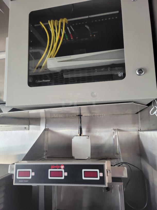 CyberPower network cabinet with yellow cables, housing Avalon Miner, in good condition, mounted above Wendy's Hot'n'Juicy order display unit.