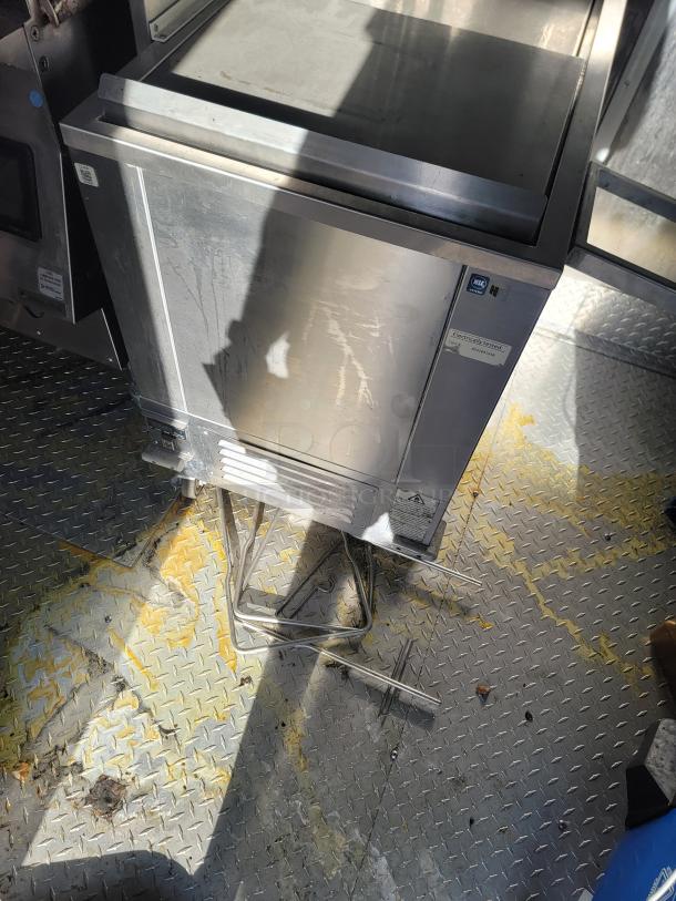 Stainless steel industrial freezer with visible wear, NSF certified sticker, and electrical testing label. Appears operational.