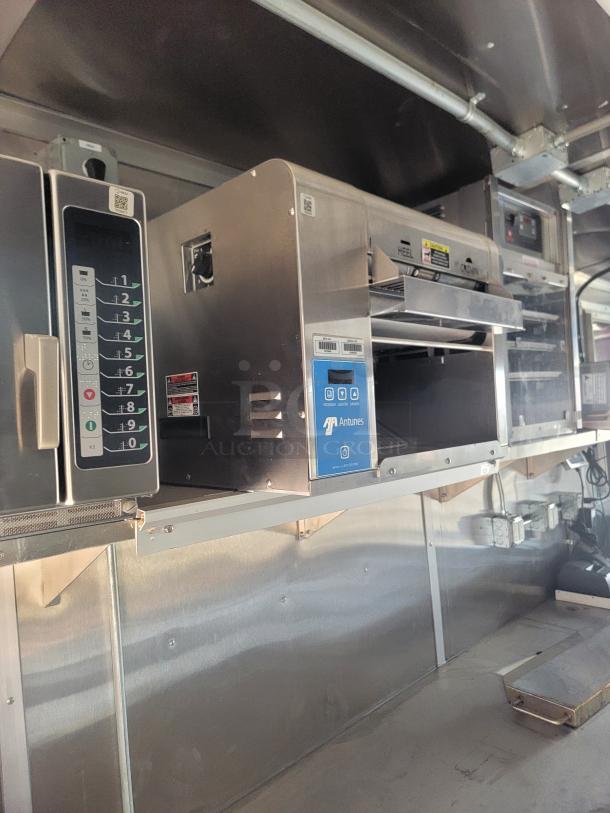 Commercial kitchen equipment including a stainless steel Antunes toaster and microwave. Features digital controls and preservation tags. Condition appears well-maintained.