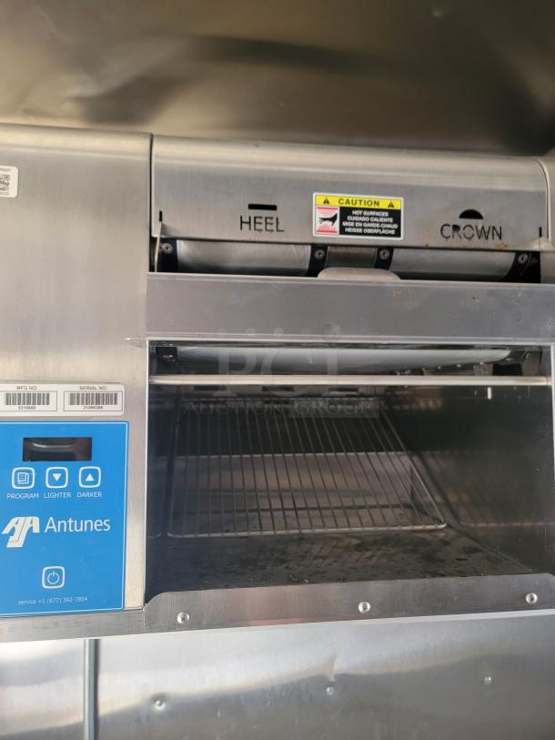 Antunes toaster with stainless steel finish, featuring "HEEL" and "CROWN" labeling. Program controls for lighter and darker settings visible.