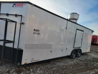 Pace American trailer with "REEF GS 8769" marking, in good condition. Features dual axles, rooftop equipment, and side door.