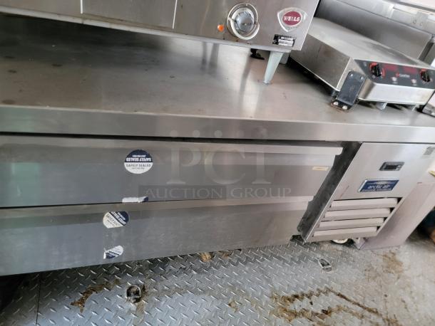 Stainless steel commercial kitchen equipment featuring Wells appliance and Arctic Air cooler with safety seals, used condition.