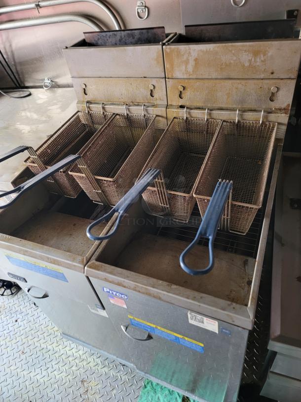 Commercial deep fryer with multiple baskets, Pitco brand. Shows signs of use. Ideal for restaurant kitchens.