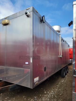 Stainless steel mobile trailer with surveillance cameras and lighting, triple axle, exterior vents, roof-mounted dish, minor wear.