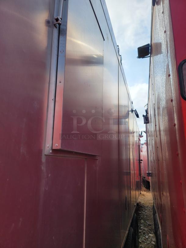 Red industrial trailer with metal finish, marked "LEXINO," showing external paneling and fittings, in good condition.