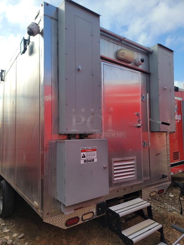 Mobile operations trailer with metal exterior. Features power input panel labeled "ROAM" and mounted camera. Good condition.