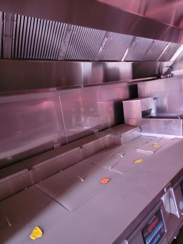 Commercial stainless steel kitchen ventilation hood, featuring a series of exhaust filters. Good condition, designed for efficient air filtration.