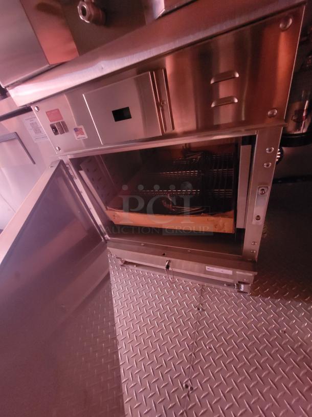 Commercial oven with open door, showing interior racks. Stainless steel exterior. Features U.S. made label.