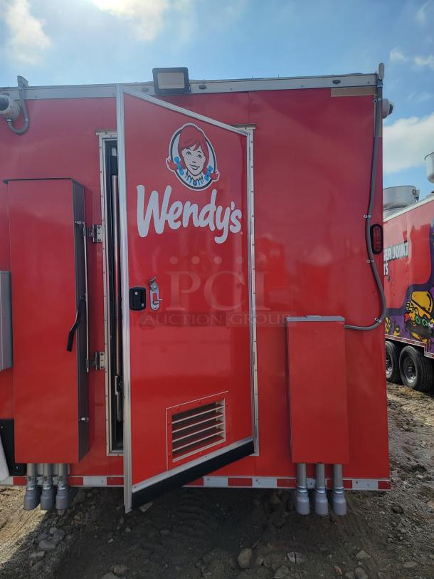 Red Wendy's food truck with logo, side door open. Visible ventilation and electrical components. Good condition for auction.