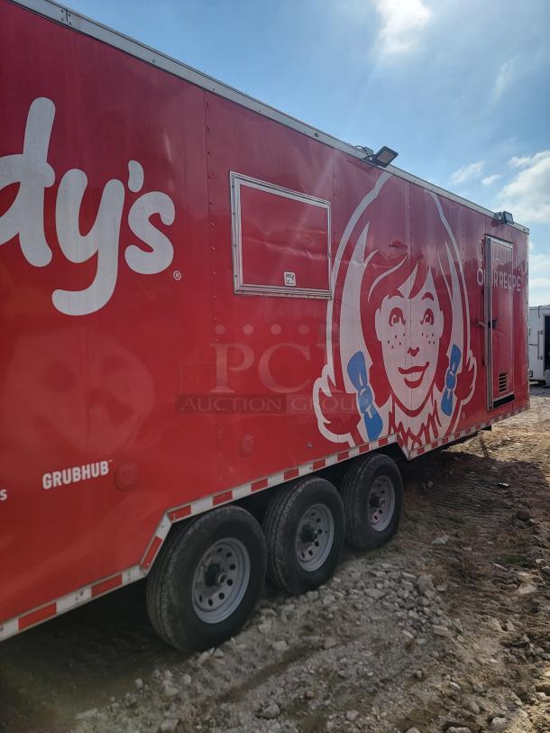 Red food trailer with three wheels, featuring Wendy's logo. Grubhub marking visible. Some wear from outdoor exposure.