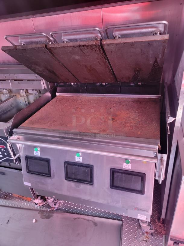 Commercial griddle with three adjustable steel plates, moderate wear, stainless steel body, labeled controls, diamond plate flooring.