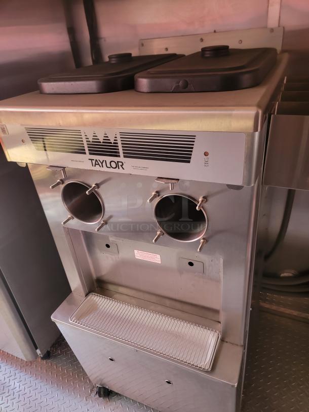 Taylor commercial ice cream machine with dual hoppers, stainless steel finish, model shows signs of use.